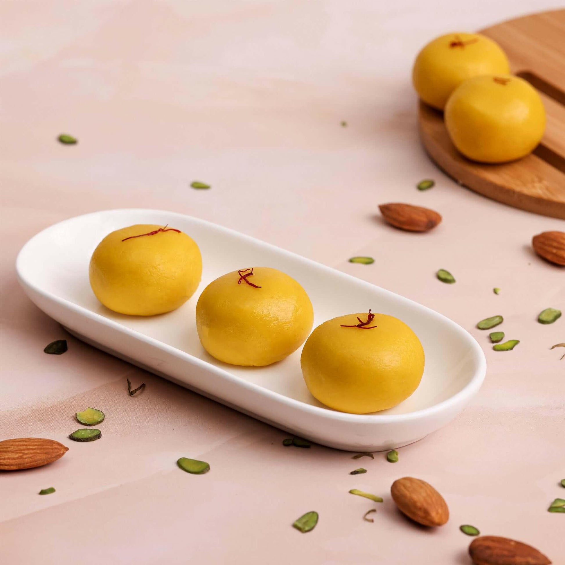 Image of Kesar Peda: "A plate of golden Kesar Peda, a traditional Indian sweet made with milk, sugar, and flavored with saffron