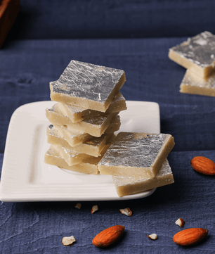 An overhead shot of a festive spread with Badam Burfi among other sweets, illustrating the variety of traditional Indian desserts.