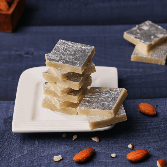 An overhead shot of a festive spread with Badam Burfi among other sweets, illustrating the variety of traditional Indian desserts."Buy Sweets Online